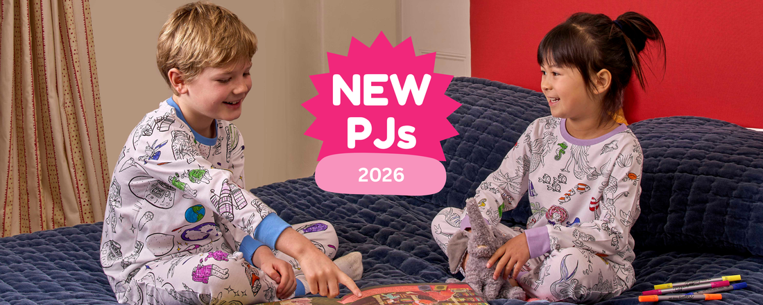 boy wearing space pyjamas sat on bed reading with girl in mermaid pyjamas