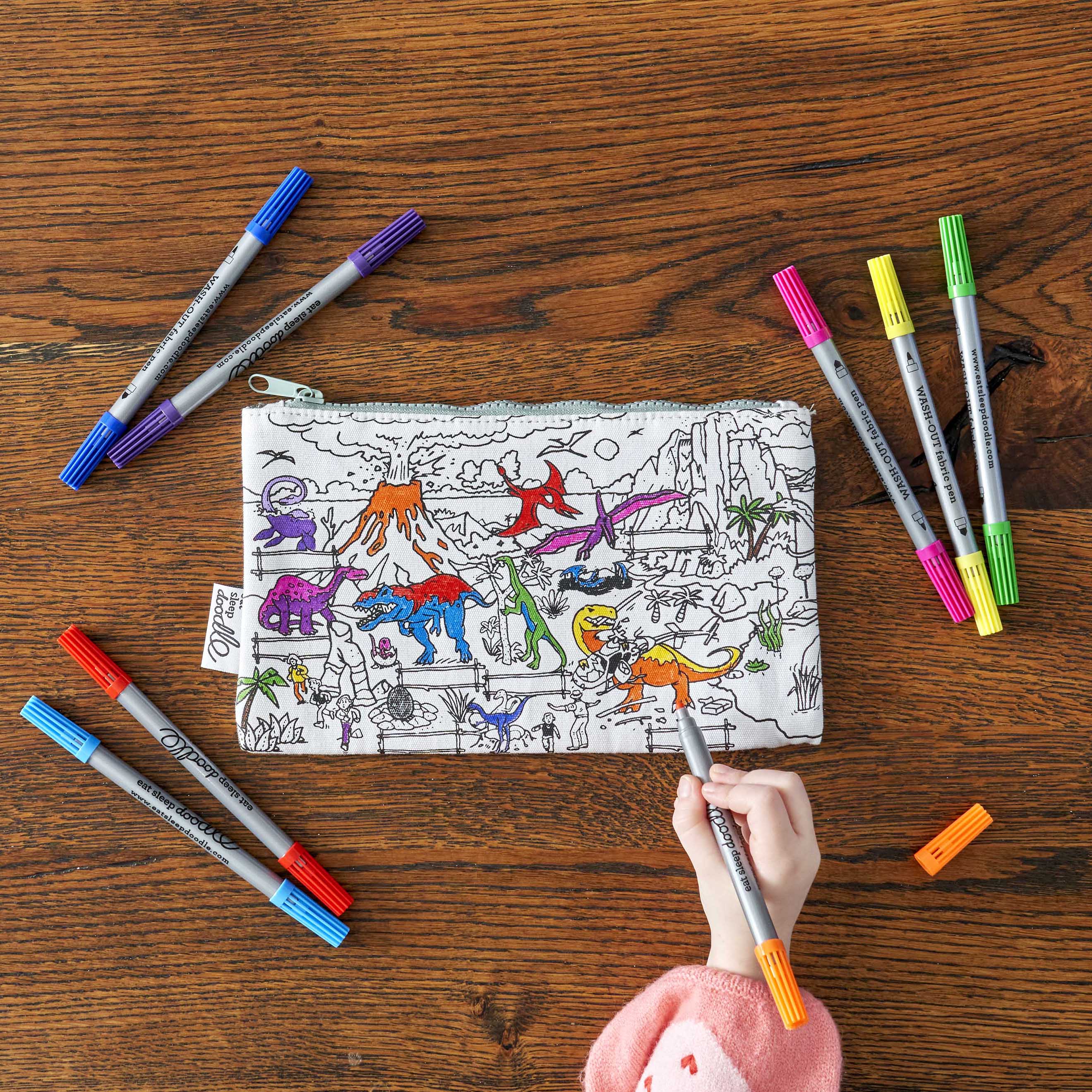 girl in pink jumper colouring in dinosaur pencil case