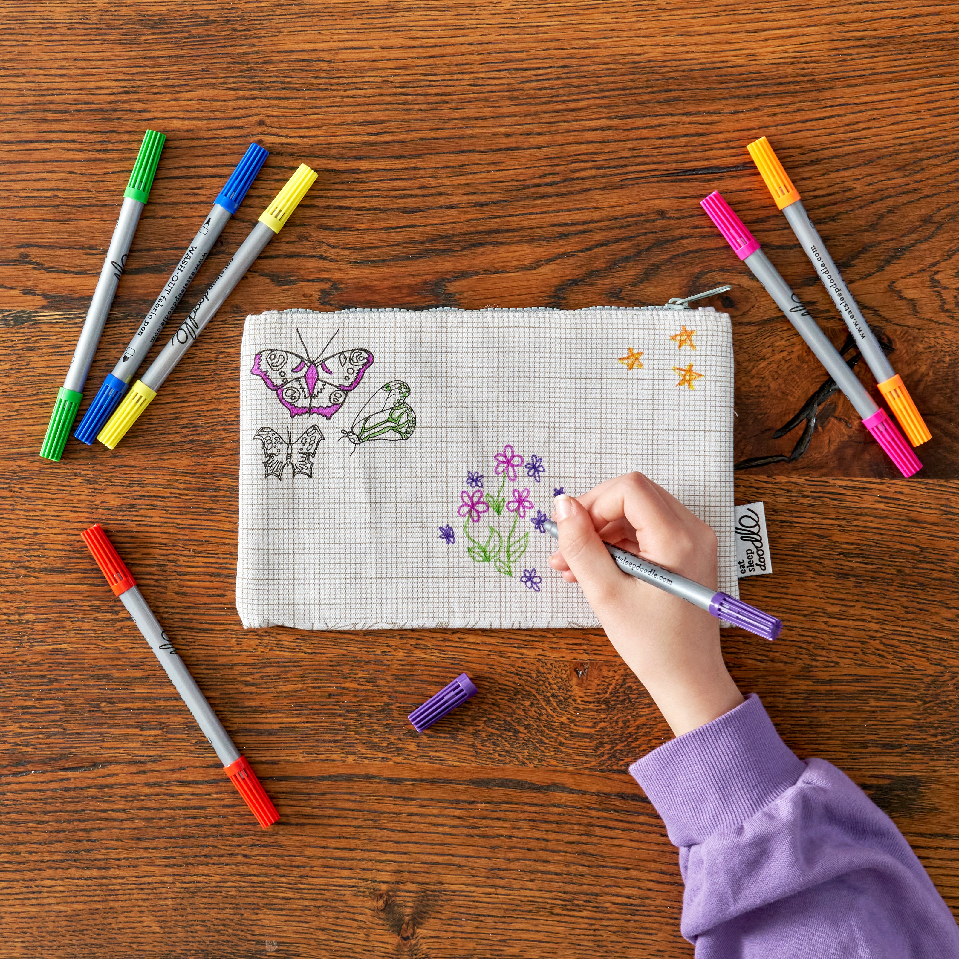 child in purple drawing on pencil case
