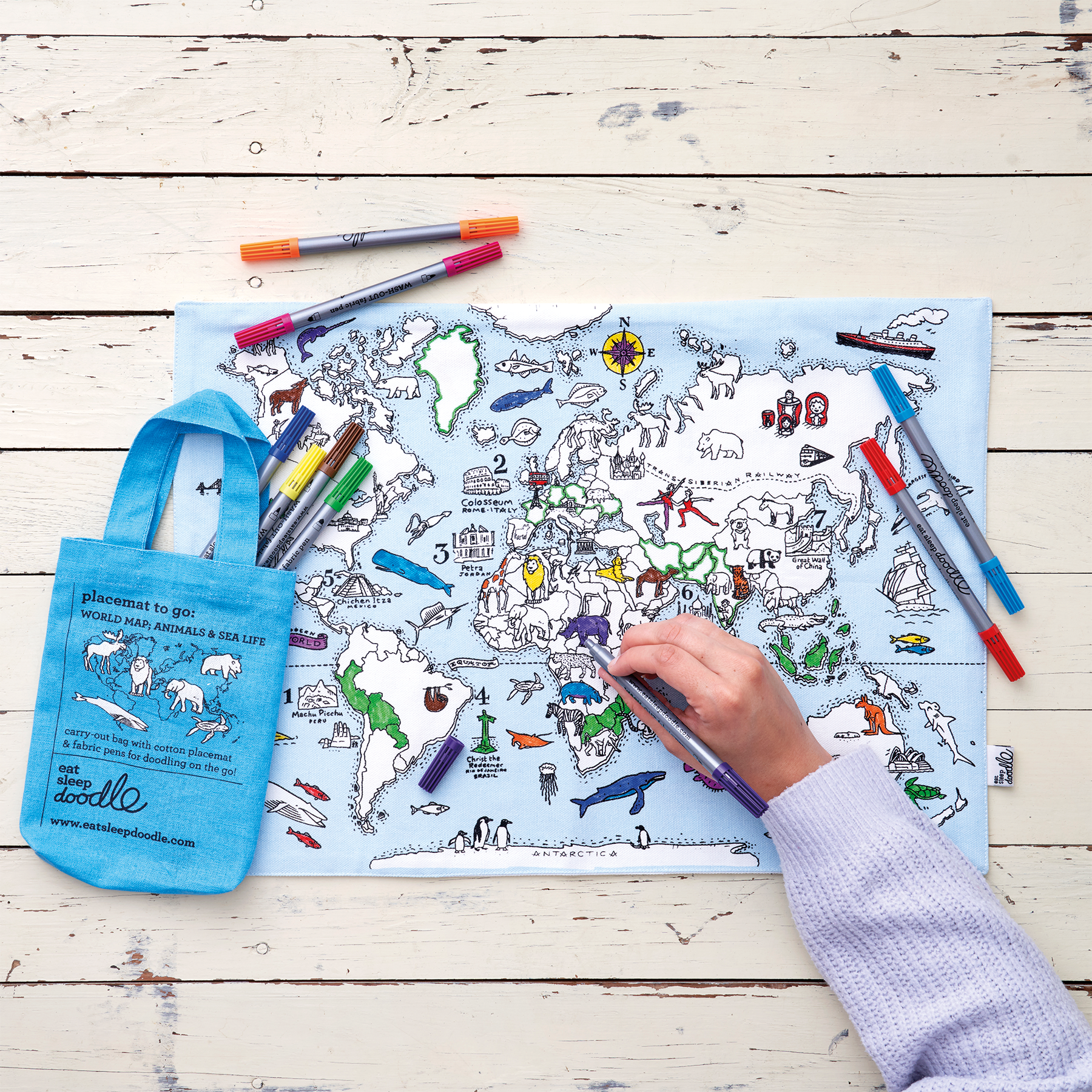 child in purple jumper colouring in world map